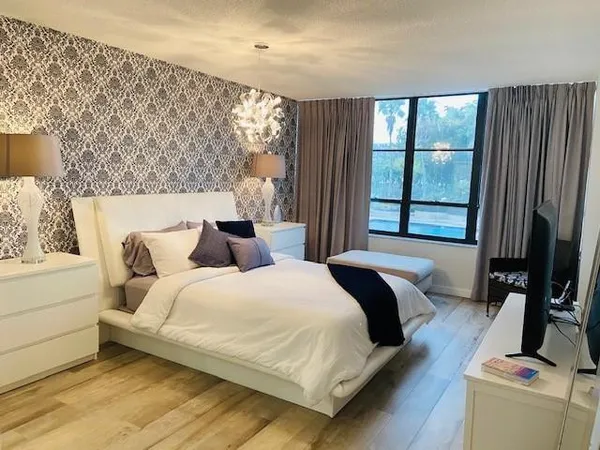 a bedroom with a bed and a flat tv screen on dresser