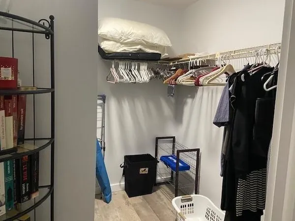 a view of walk in closet with clothes and shoes