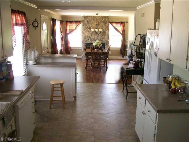 7677 Zion Church Road Staley, NC 27355 - Photo 4 of 10 Kitchen. Spacious Kitchen including a recessed area for refrigerator and Dining Room with hardwoods and rock fireplace