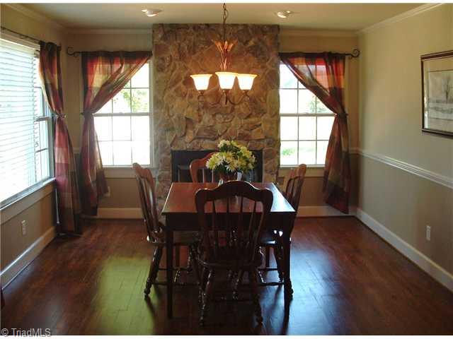 7677 Zion Church Road Staley, NC 27355 - Photo 6 of 10 Dining Room. Dining room with beautiful hardwood floors and custom fireplace with remote controlled gas logs.