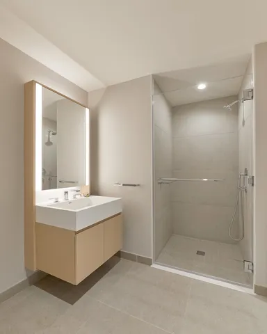 a bathroom with a bathtub shower sink and mirror