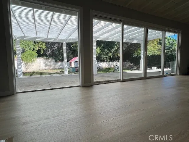 a view of a room with wooden floor and outdoor space