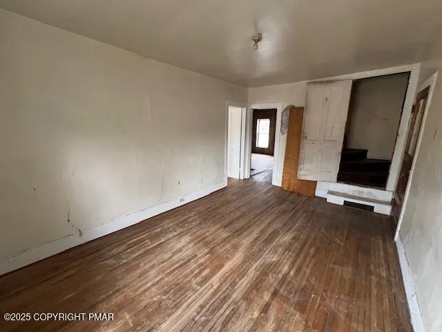 wooden floor in an empty room with a window