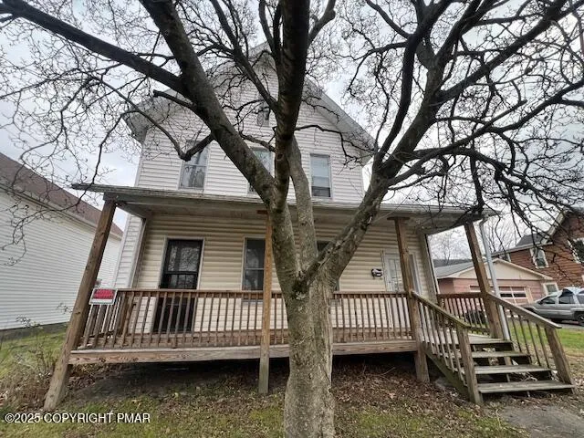 front view of a house with a large tree