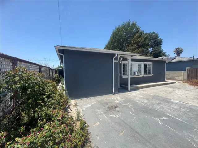 a view of a house with a yard and potted plants