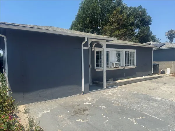 a view of a house with a yard and potted plants