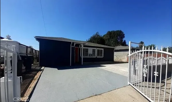 an empty room with wooden floor chandelier fan and windows