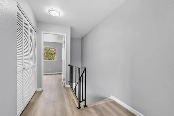a view of a hallway with wooden floor and stairs