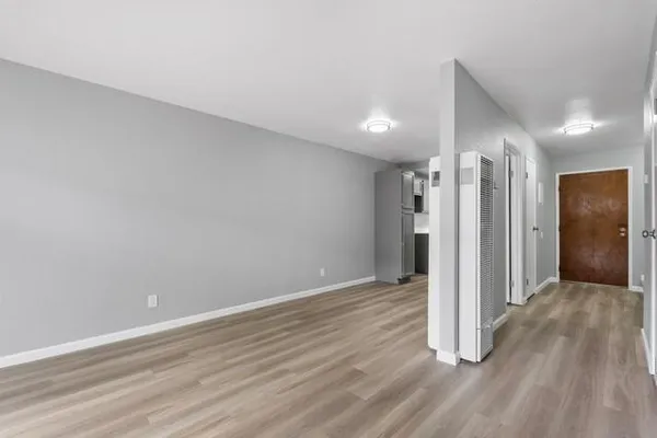 a view of an empty room with wooden floor