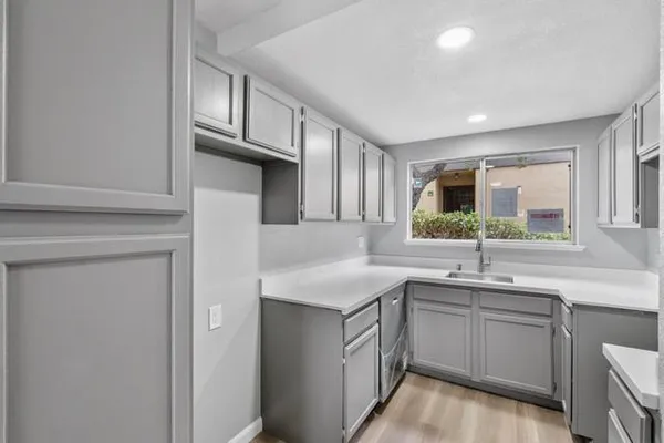 a kitchen with a sink dishwasher a stove and cabinets