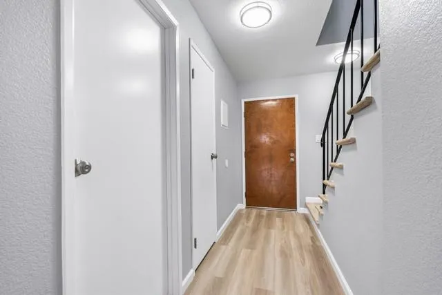 a view of a hallway with wooden floor and staircase