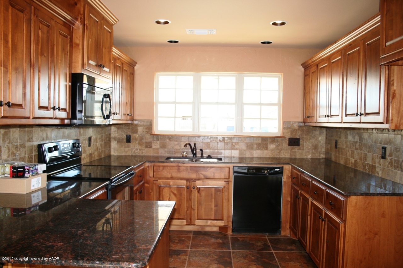 5804 South Rusk Street Amarillo, TX 79118 - Photo 5 of 18 a kitchen with stainless steel appliances granite countertop sink stove top oven and cabinets