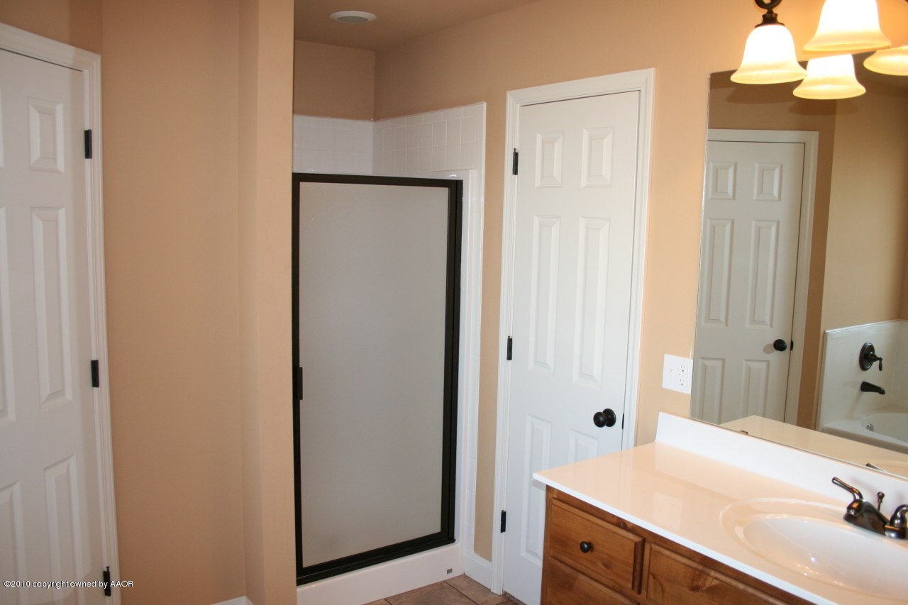 5804 South Rusk Street Amarillo, TX 79118 - Photo 10 of 18 a spacious bathroom with a sink and a mirror