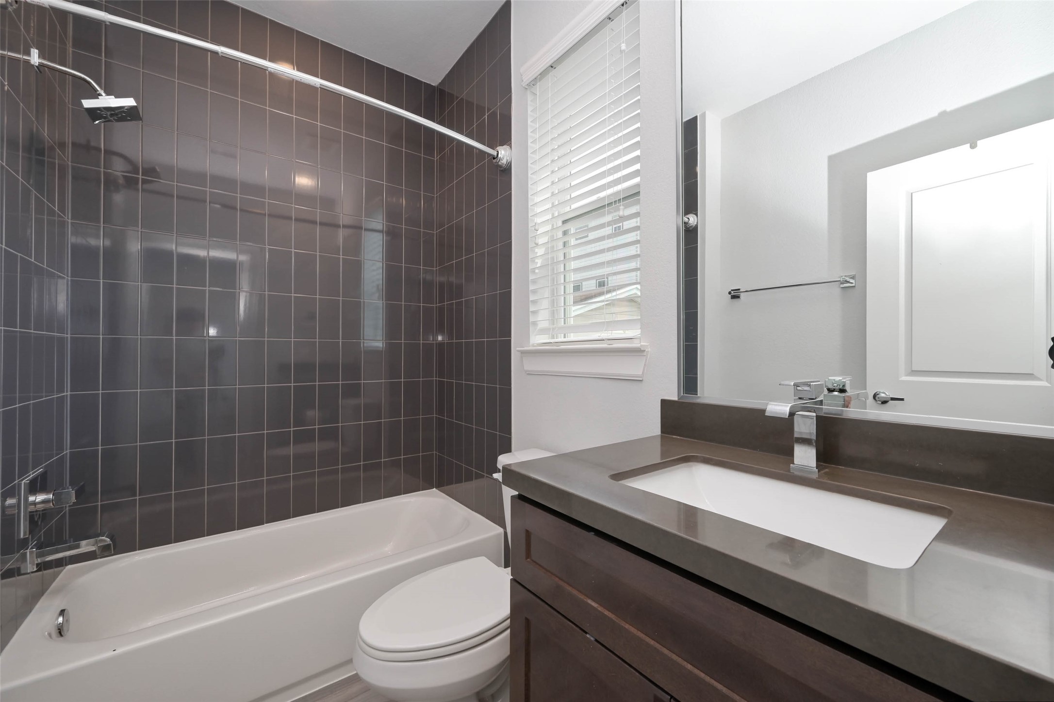 951 West 17th Street Houston, TX 77008 - Photo 8 of 30 a bathroom with a granite countertop sink toilet a mirror and bathtub