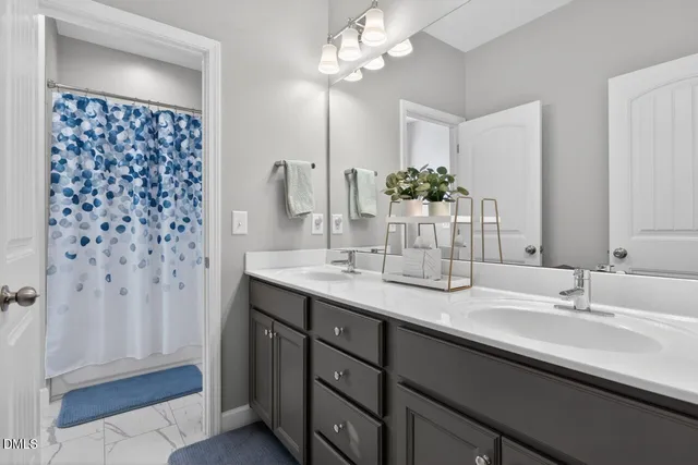 a bathroom with a double vanity sink a large mirror and a shower
