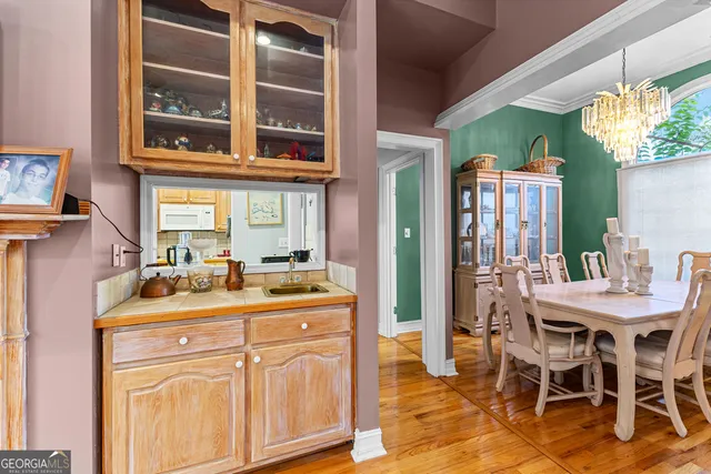 a dining hall with stainless steel appliances granite countertop a table and chairs in it