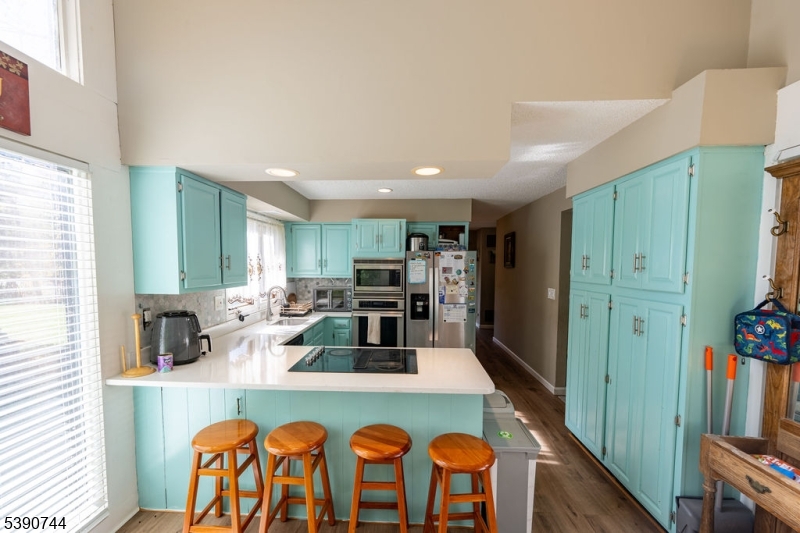 13 Village Way, Unit E7 Vernon, NJ 07462 - Photo 10 of 46 a kitchen with stainless steel appliances granite countertop a dining table chairs and a refrigerator