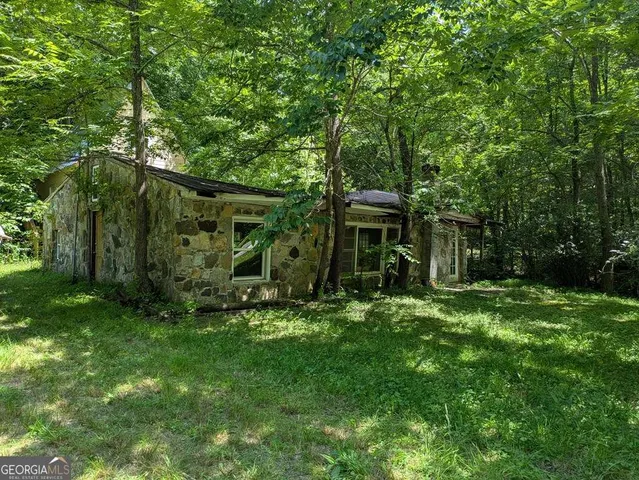 a view of a backyard with table and chairs and a large tree