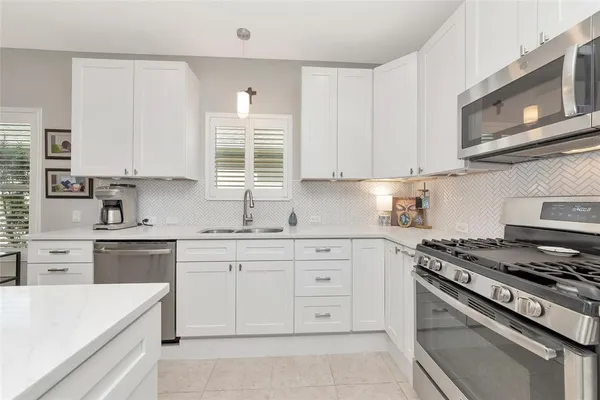 a kitchen with cabinets appliances a sink and a window