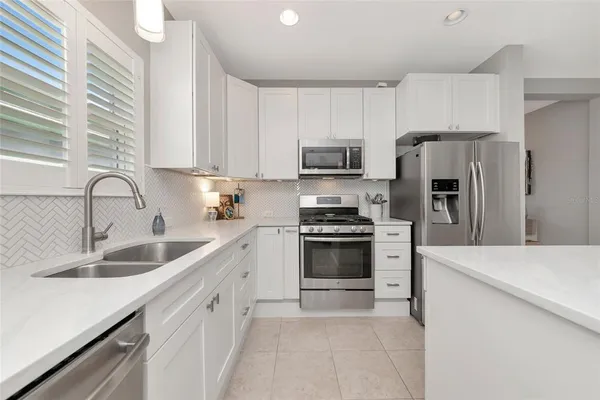 a kitchen with refrigerator a sink and a stove