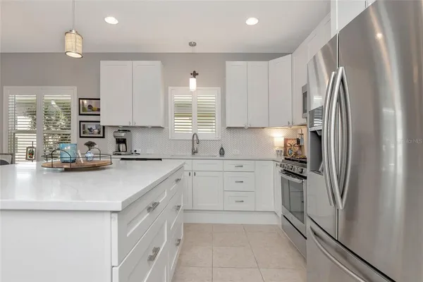 a kitchen with white cabinets and stainless steel appliances