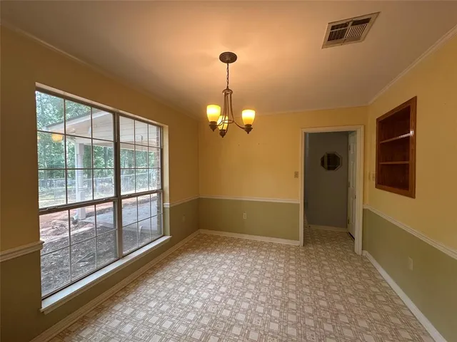 a view of a livingroom with a chandelier fan and windows
