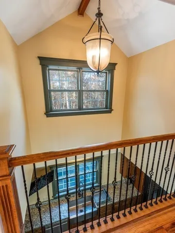 a view of a hallway with wooden floor and chandelier