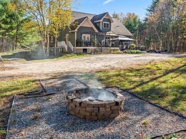 a front view of a house with a yard covered with trees