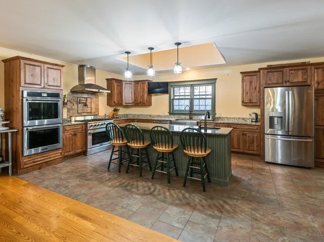 a kitchen with stainless steel appliances granite countertop a stove refrigerator and cabinets