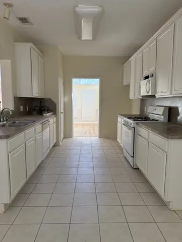 a kitchen with a stove top oven sink and cabinets