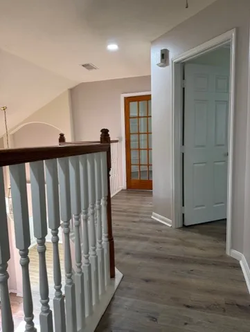 a view of a hallway with wooden floor and entryway