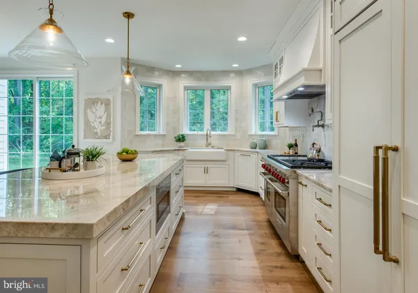 a large kitchen with stainless steel appliances granite countertop a lot of counter space and wooden floors