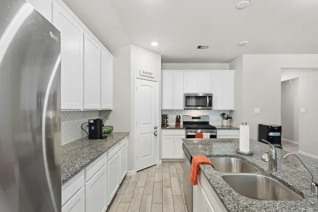 a kitchen with stainless steel appliances granite countertop a sink stove and refrigerator