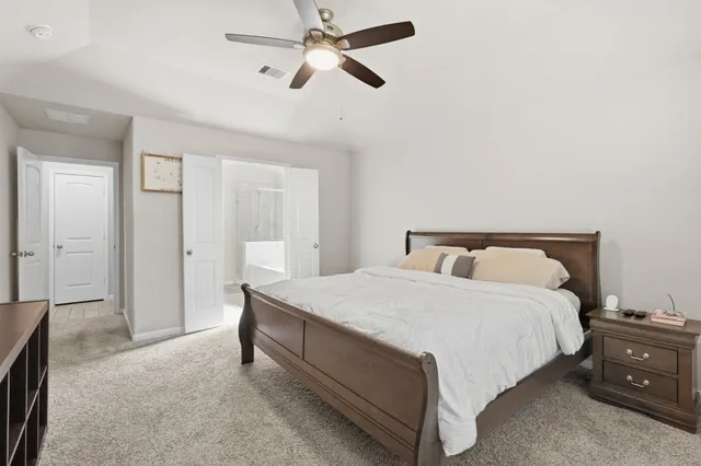 a spacious bedroom with a bed and a chandelier
