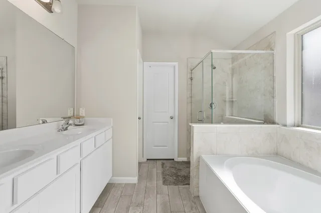a bathroom with a tub sink and mirror