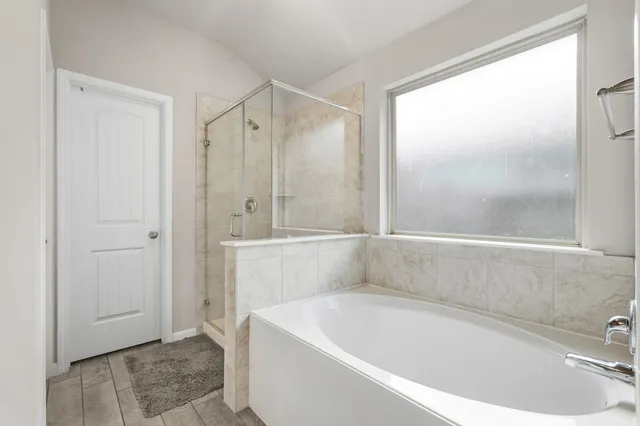 a white bath tub sitting next to a shower