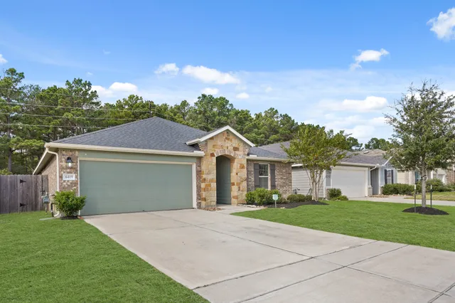 a front view of a house with a yard and trees