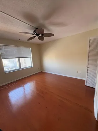en empty room with windows and ceiling fan