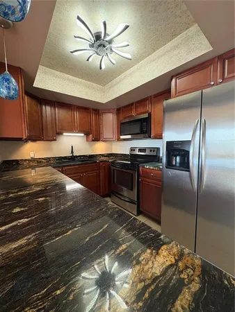a kitchen with stainless steel appliances granite countertop a stove refrigerator and a microwave oven