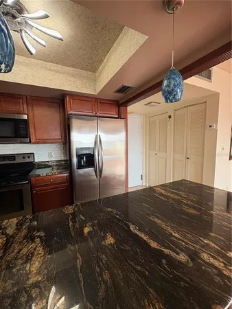 a kitchen with a refrigerator and a stove top oven