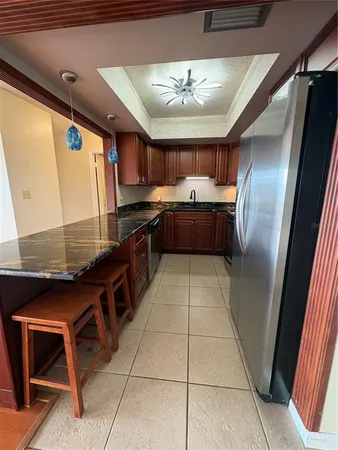 a kitchen with stainless steel appliances granite countertop a sink and a refrigerator