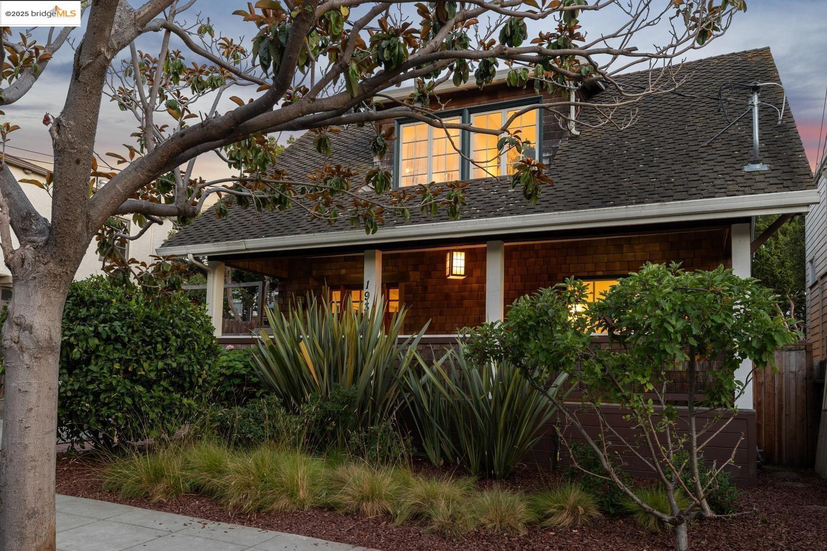 a view of a house with a tree in front of it