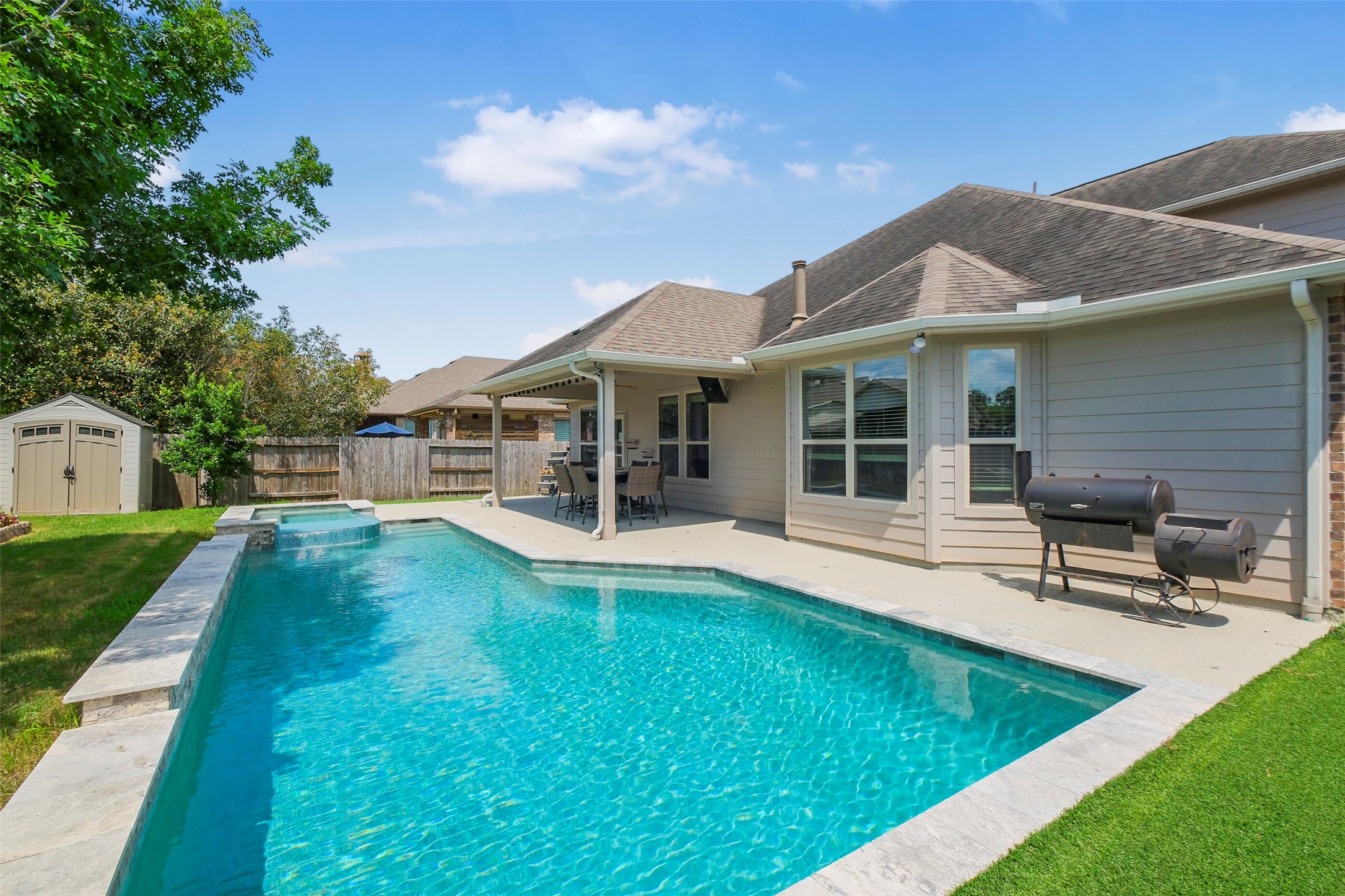 30014 Valley Terrace Drive Fulshear, TX 77406 - Photo 2 of 36 Slip out back to your own oasis! The pool/spa was built in 2021 with a waterfall feature and infinity edge hot tub.