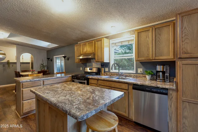 a kitchen with a stove a sink a refrigerator and wooden cabinets