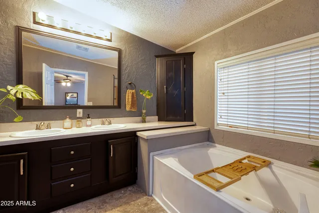 a bathroom with a tub sink and mirror