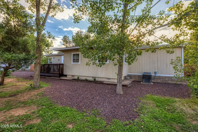 a view of a backyard with wooden fence and a tree