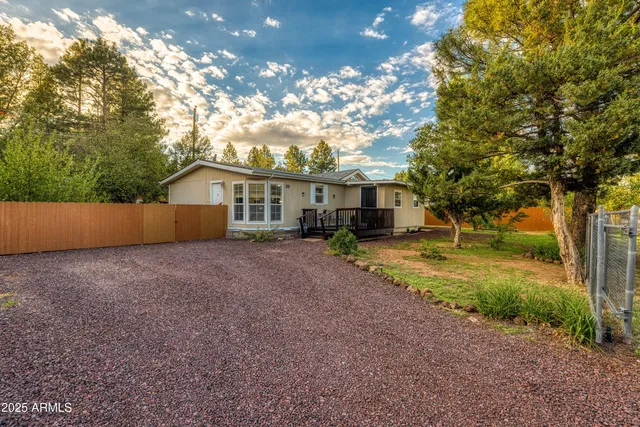 a view of a house with backyard and tree