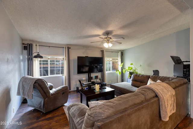 a living room with furniture a flat screen tv and a large window