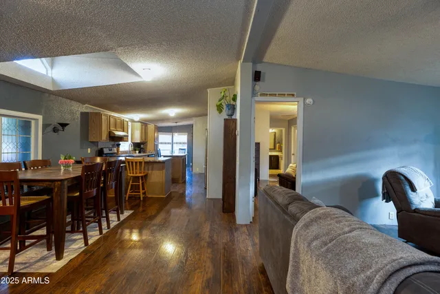 a living room with furniture a dining table and wooden floor