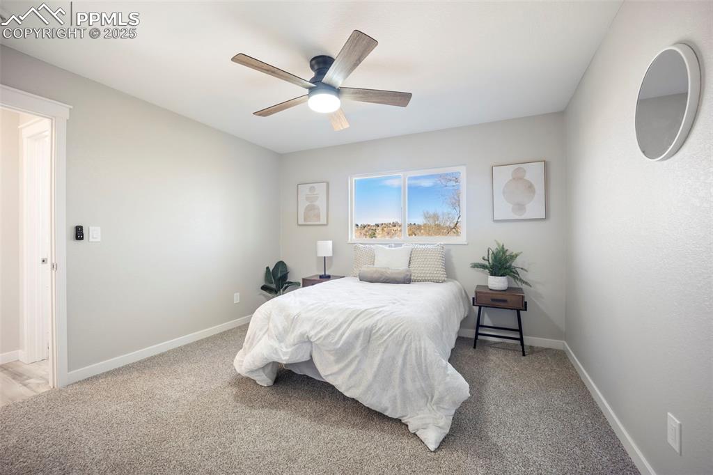 2010 Hampton South Colorado Springs, CO 80906 - Photo 25 of 45 a bedroom with a bed and a chandelier